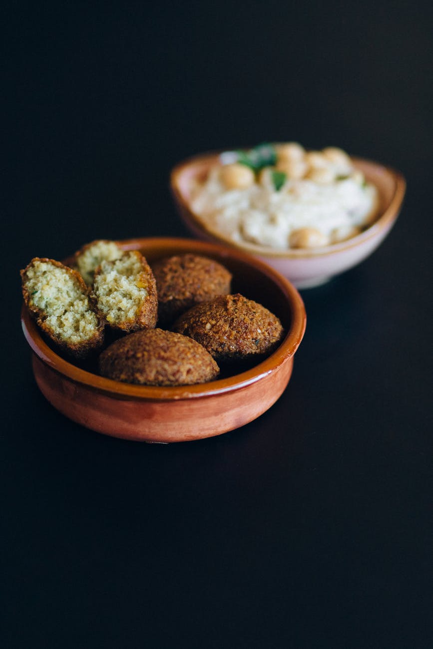 close up photo of fried falafels in a brown bowl